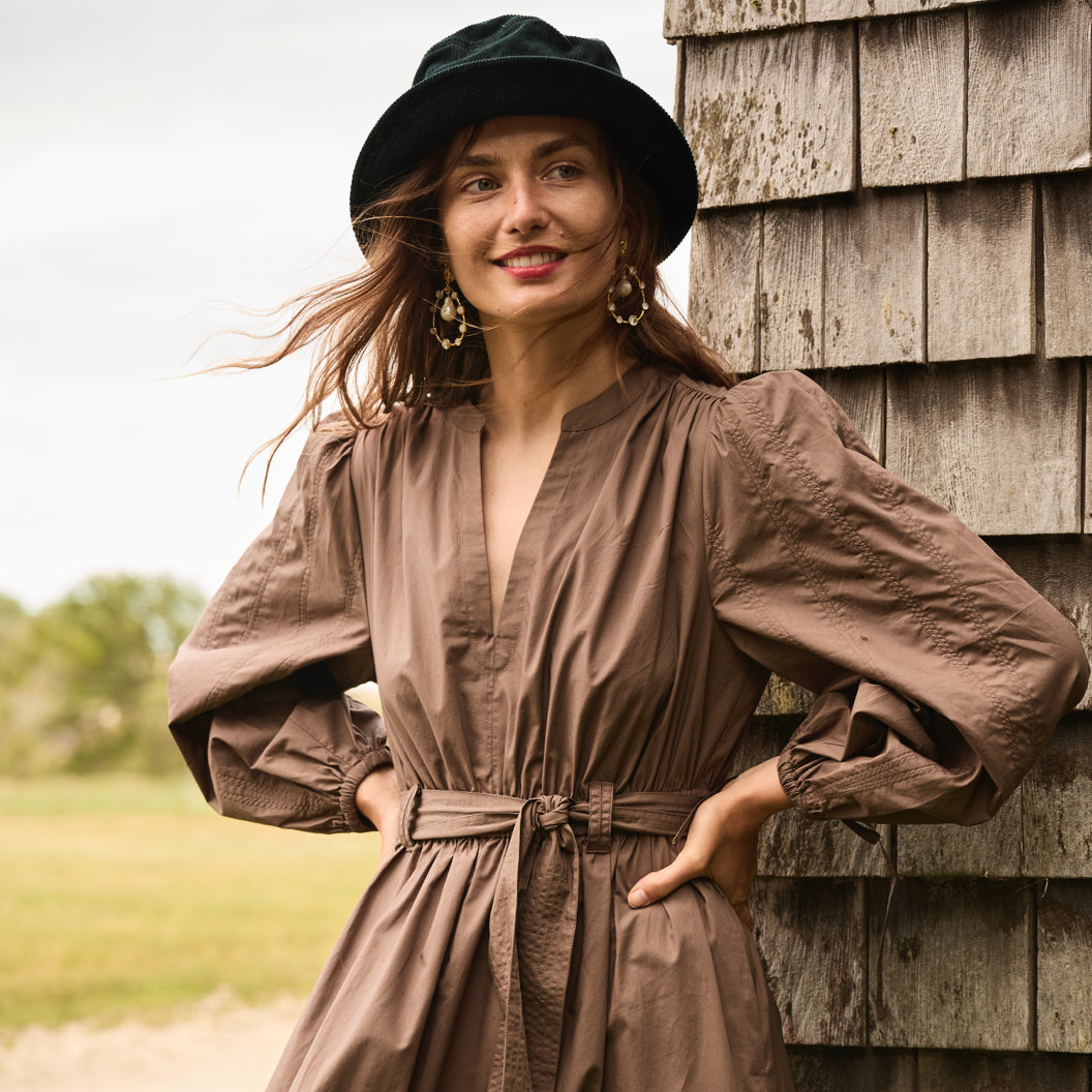 Individual wearing a brown J.Crew belted shirtdress and a sunhat