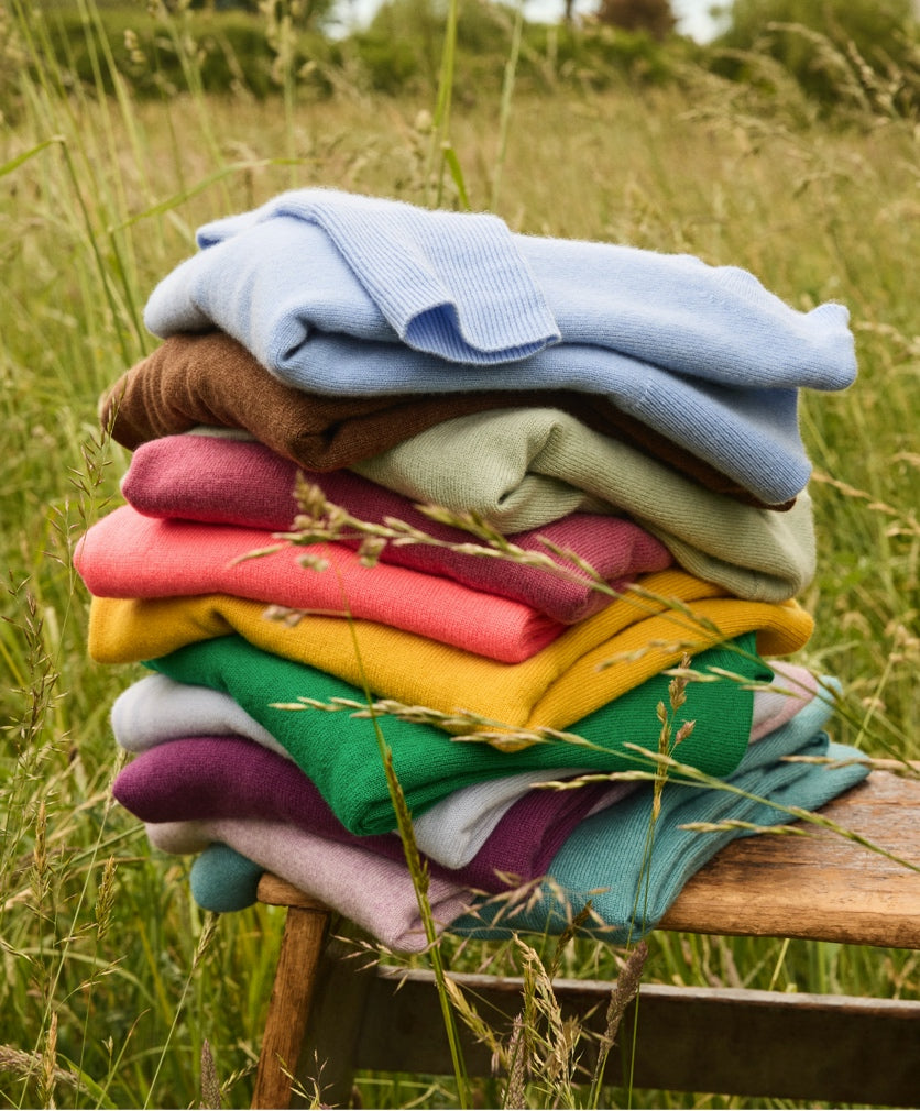 Neatly folded pile of J.Crew cashmere sweaters 